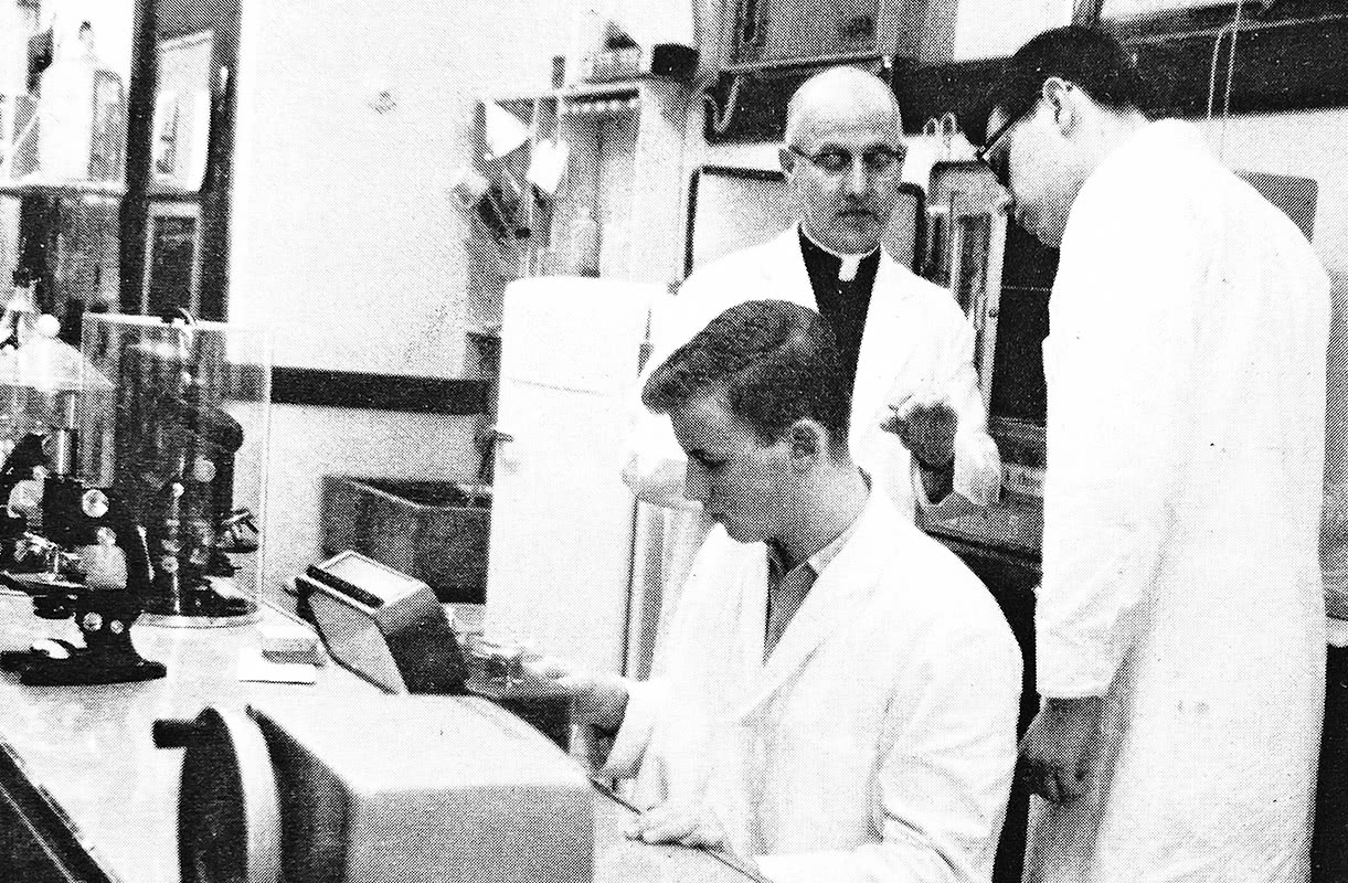 Vintage black and white photo of students and faculty working in a science lab