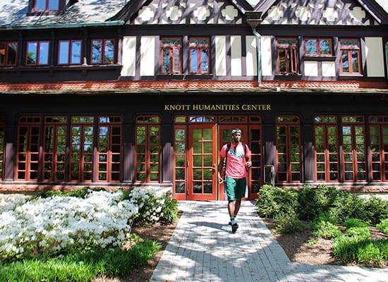A student walking in front of the Humanities building