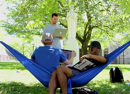 Students studying on the Quad while lounging in hammocks