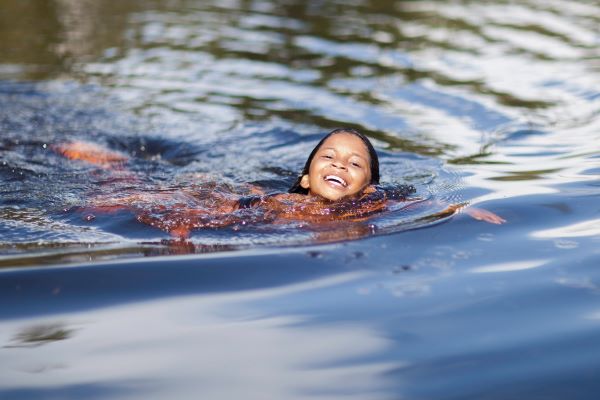 smiling child swimming in a river