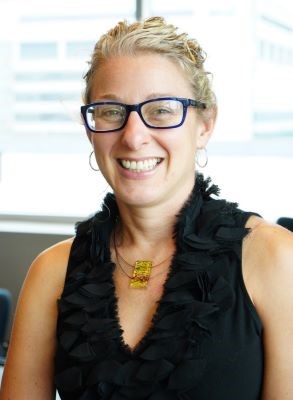 blond woman with glasses by window