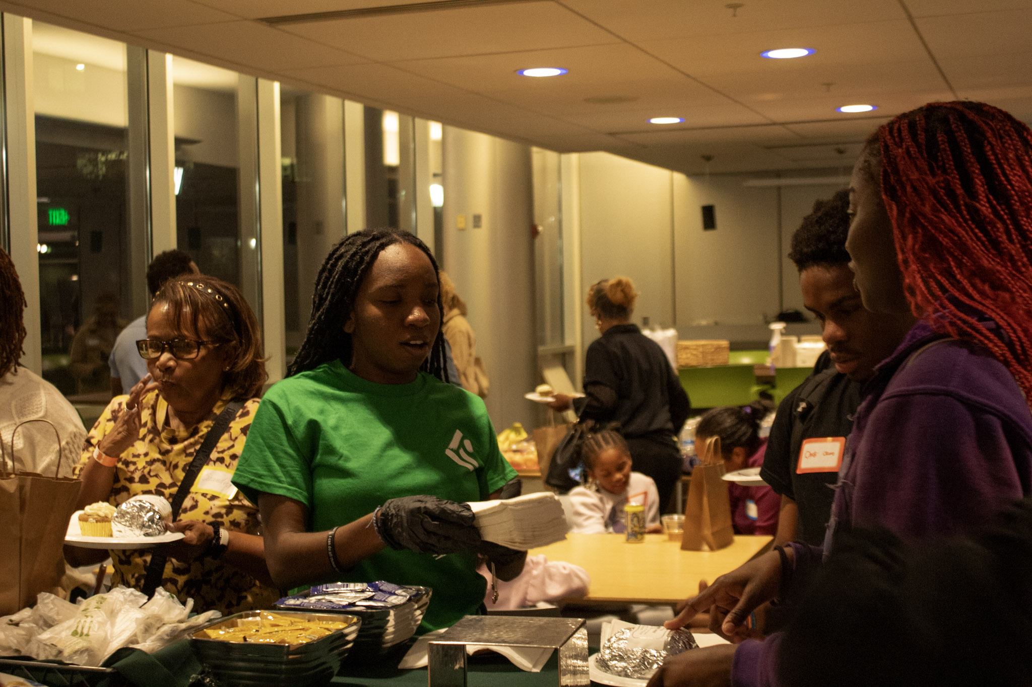 Karson Institute intern Sarah Naje hands napkins out to students seeking catered meals