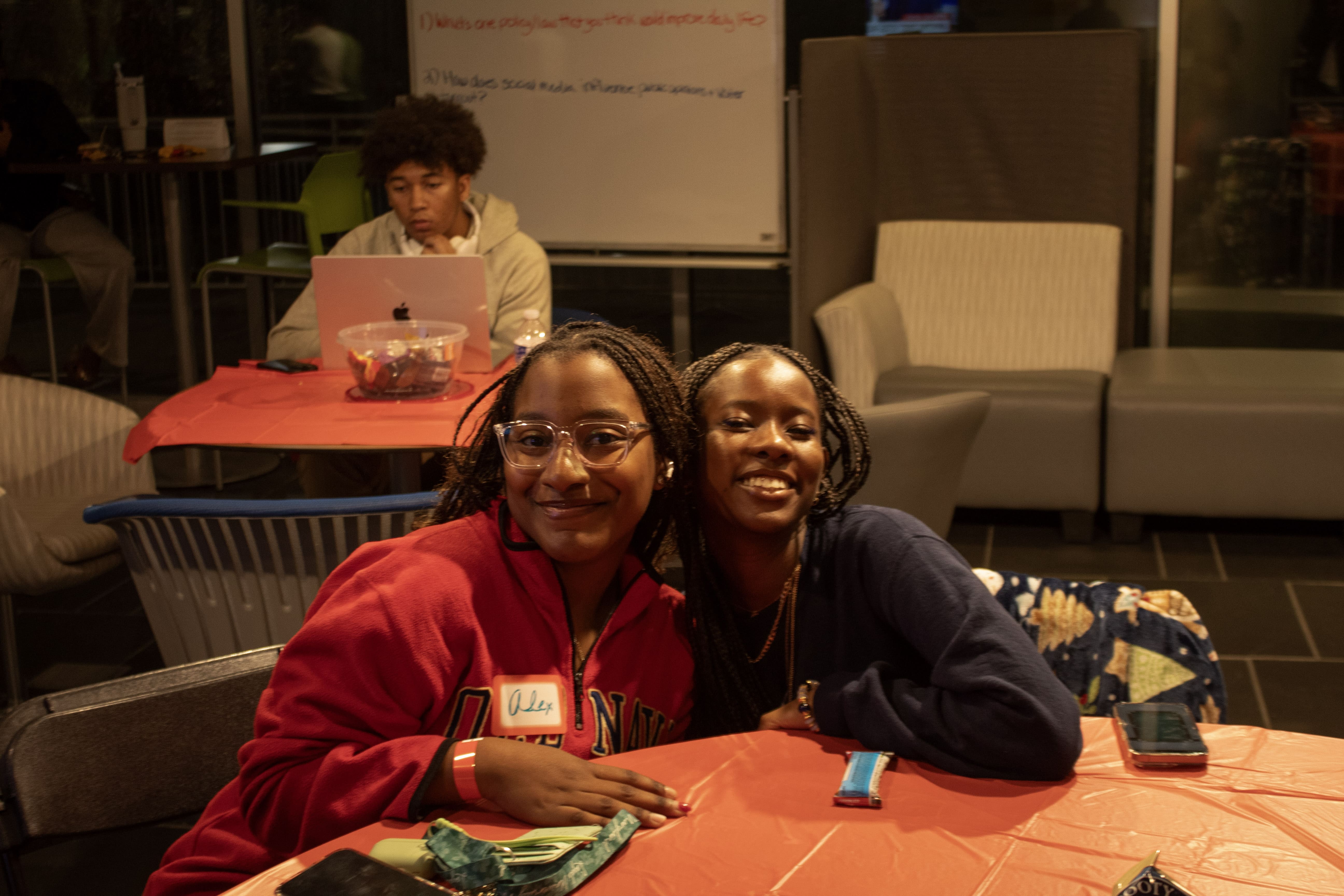 2 young women hug and smile at the viewer during a Karson event