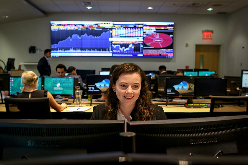 A student sits at a computer in a classroom in Loyola