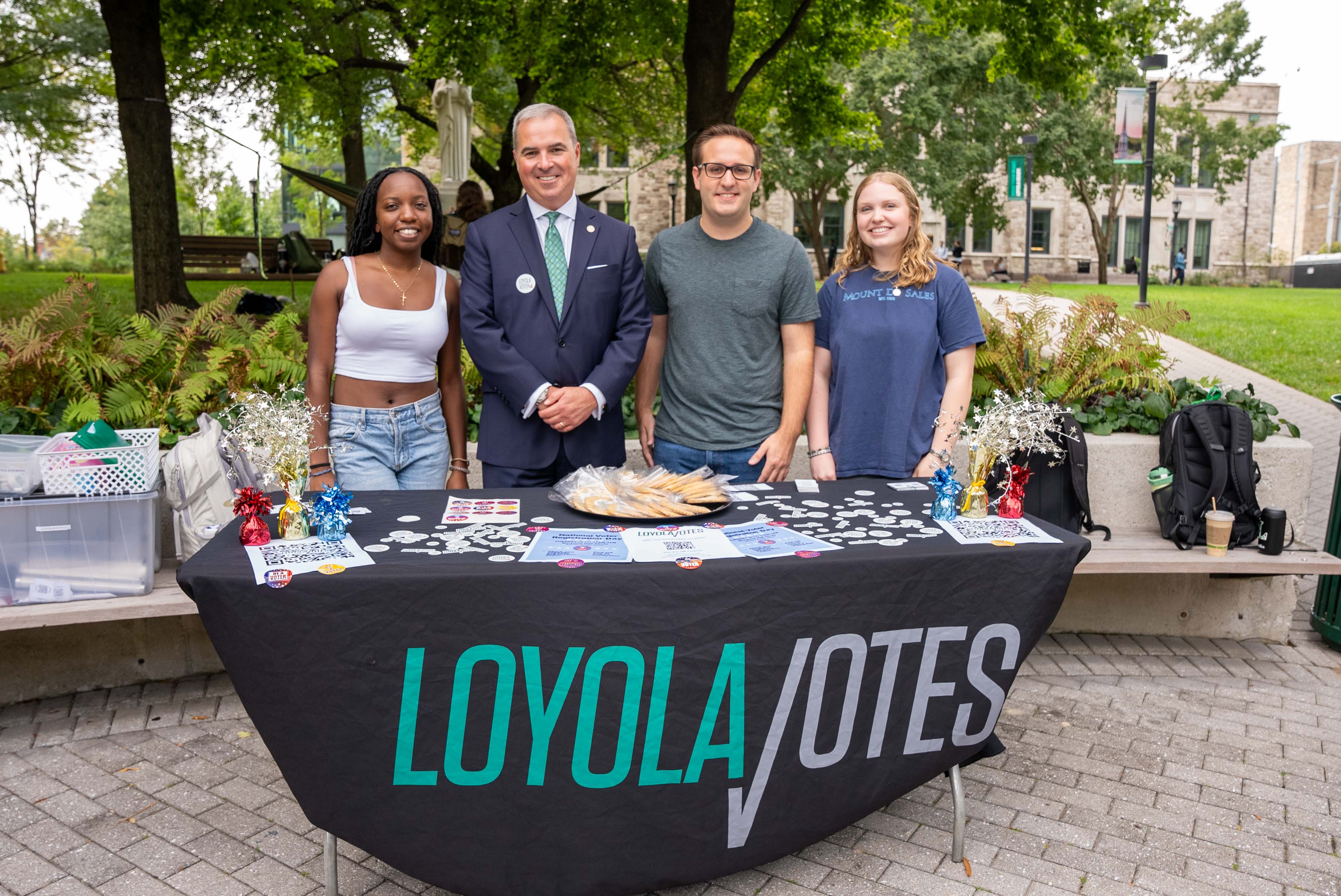 President Sawyer with students at a LoyolaVotes information table on the Quad.