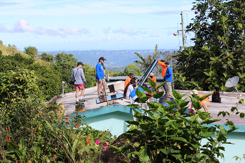 Loyola students work with ISO to install the solar panels.