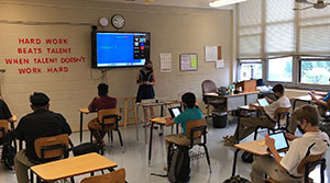 Sarah Flaherty teaching her students in-person and via Zoom