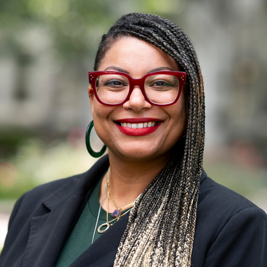 Kristina Collins headshot with Loyola evergreen campus in the back