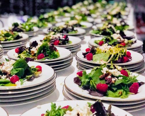 Rows of dozens of salad plates prepped and ready to serve