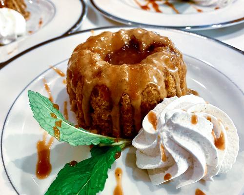 Mini bundt cake dessert with icing drizzle artfully plated with whipped cream