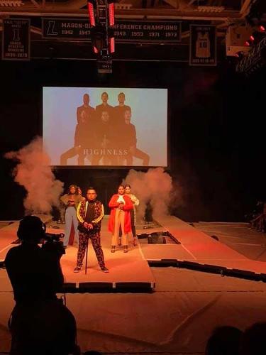 Models posing at the end of the catwalk while a photographer captures the moment 