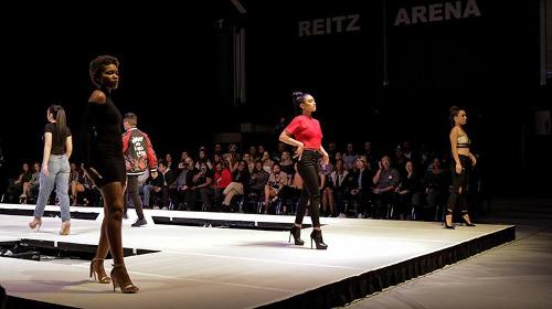 Three female models lined across the top of the catwalk.