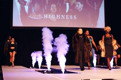 Male and female models walking down the runway dressed in a dark color scheme.