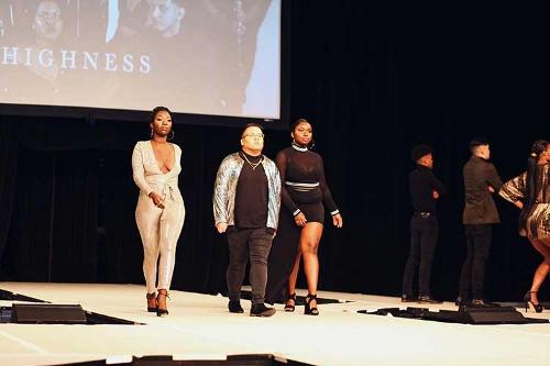 Three student models walking side-by-side down the catwalk.