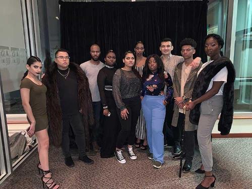 A group of student models posing back stage the night of a show.