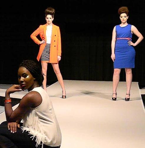 2 female models mirror poses in bright colored dresses while one model in black and white poses front and center.